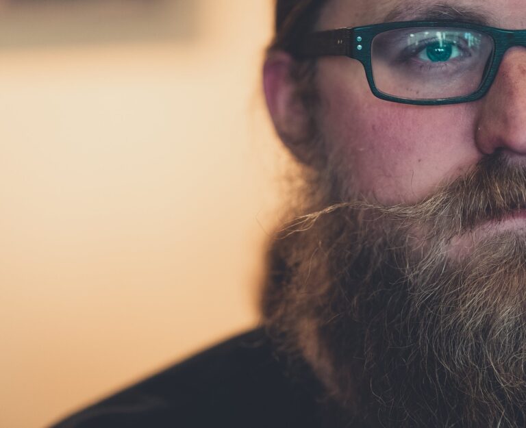 Close-Up Photo of Man Wearing Eyeglasses with a beard