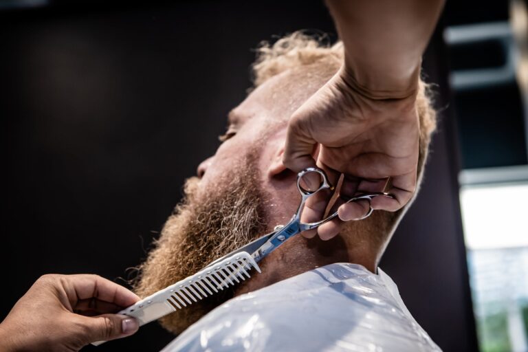 Hands of a Person Trimming a Man's Beard