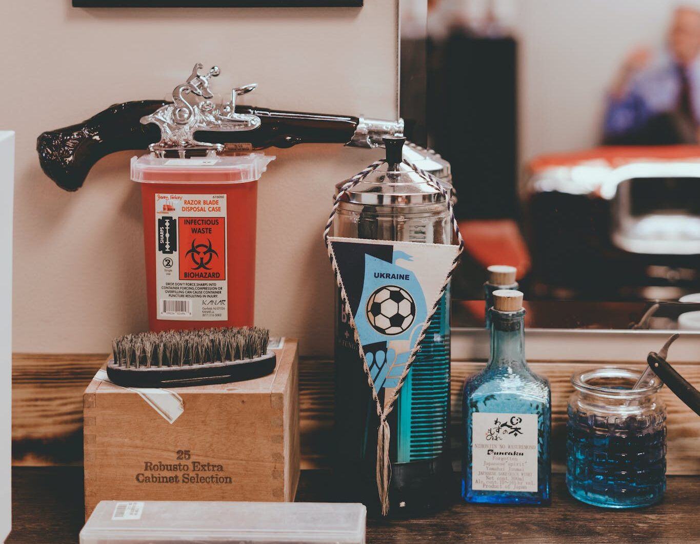 Various hair and beard care products and comb placed near mirror on wooden table of old fashioned barbershop